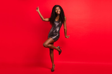 Full body photo of young attractive afro woman happy positive smile wear dress look empty space isolated over red color background