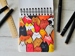 Sketch of cat pattern on wooden background with markers