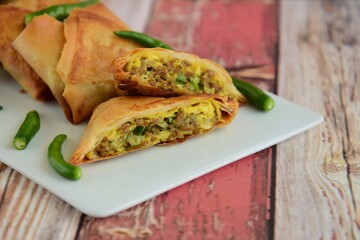Homemade Martabak Telur, Indonesian cuisine. Pan-fried wrap filled with ground beef, egg and scallion. Served with green chilli Rawit