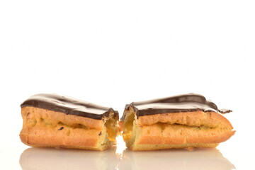One sweet chocolate eclair cut in half, close-up, isolated on white.