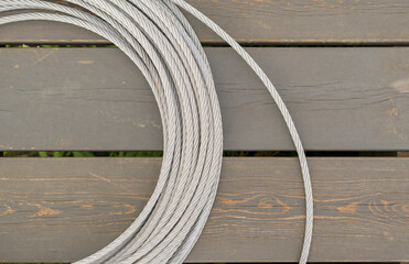 Twisted steel braided rope. Background - dark wooden boards.