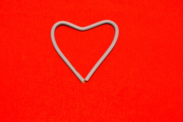 Feast of St. Valentine. Heart made of white wires on a red background. Background, design.
