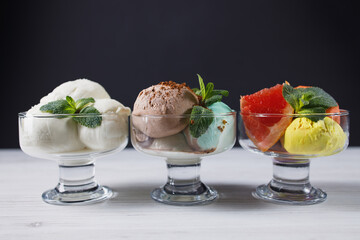 Set of ice cream scoops of different colors and flavors in glass sundae bowls. Summer delicious food, tasty refreshing dessert