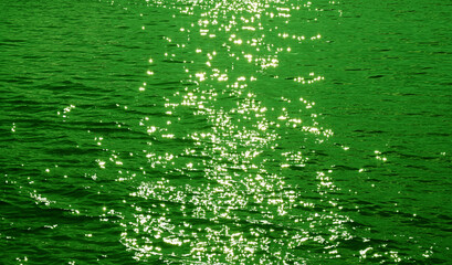 Pop art surreal style green colored sparkling water surface with sea ripples