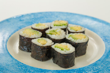 vegetarian Sushi with avocado on white and blue plate isolated on a white background