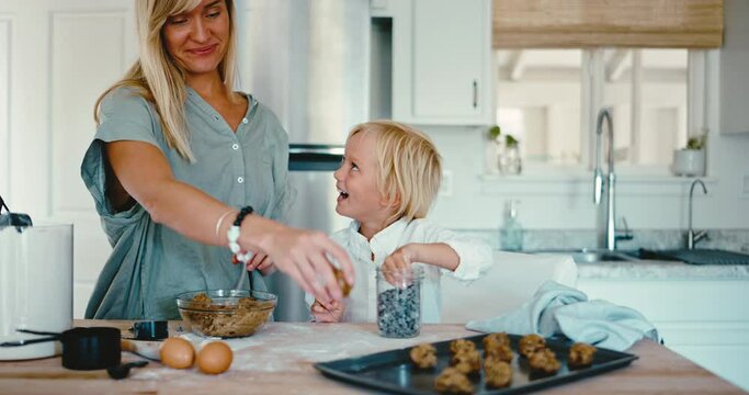 Cute mother and son baking in the kitchen spending quality time together, having fun with family, delicious treats