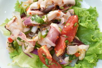 Thai spicy squid salad and fresh vegetable on plate