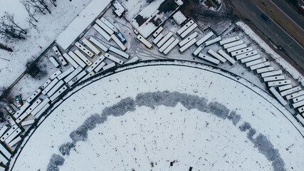 Top view aerial shot of famous Kyiv abandoned round bus park covered wtih snow, Ukraine