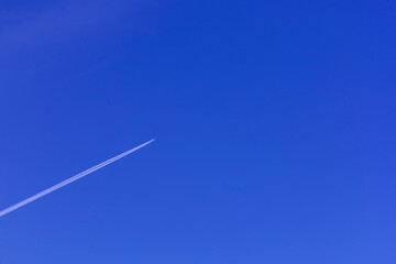 trail of a flying aircraft against the background of cloudless sky