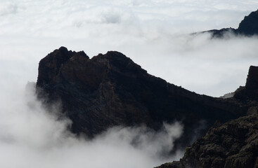 Cliffs of a volcanic crater and sea of clouds.