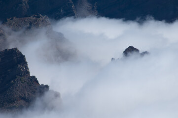 Cliffs of a volcanic crater and sea of clouds.