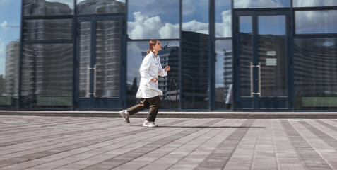 Fototapeta na wymiar concerned female doctor quickly runs down the street .
