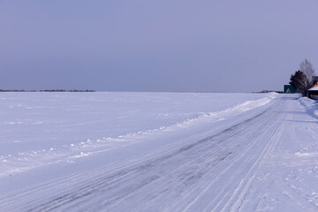 road leading to the village through the snow plain