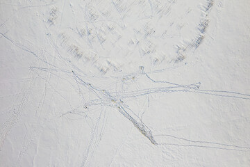 Obraz premium View from above of footprints and blue shadows on white snow