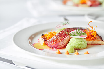 Tender dorado fillet with vegetables and basil. Banquet festive dishes. Gourmet restaurant menu. White background.