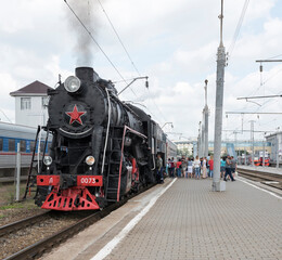 Obraz premium Passengers sit in a car, driven by a steam locomotive