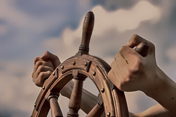 Steering hand wheel ship on sky background, hand hold hand wheel