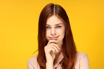 cheerful pretty woman gesturing with her hands near face emotions yellow background