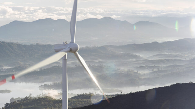 Green renewable alternative energy concept - wind generator turbines generating electricity. Landscape with windmills 