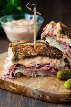 Close Up Of Reuben Sandwiches Served With Pickles And Russian Dressing.