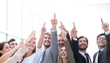 group of confident young people, pointing somewhere up.