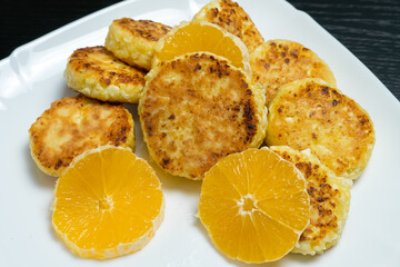 Cottage cheese pancake with orange slices on a white plate. Concept of delicious Breakfast