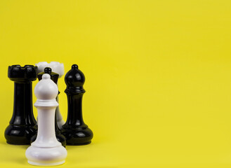 Large chess pieces on a yellow background.
