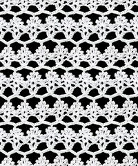 Seamless knitted texture. This beautiful floral pattern is crocheted with white threads. Cotton yarn.