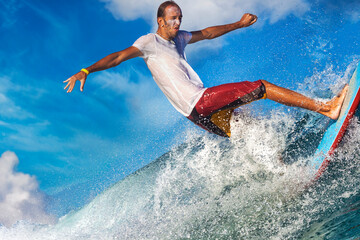 Naklejka premium Male surfer on a blue wave at sunny day