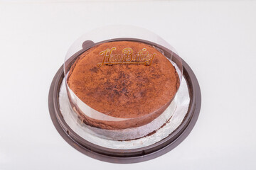 An unneat chocolate cake with happy bithday sign