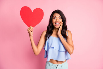 Photo of impressed brunette lady hand face show paper heart wear blue top isolated on pastel pink color background