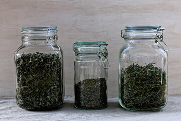 Dried herbs in glass jars: mint, lemon balm and garden thyme. Healthy lifestyle alternative...