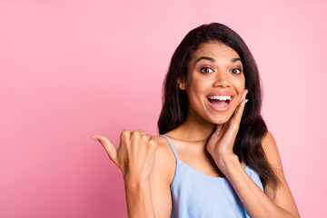 Photo of impressed brunette lady point empty space hand face wear blue top isolated on pink color background