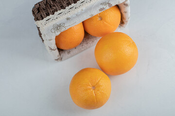 A wooden basket full of fresh orange fruits