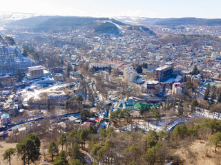 Fototapeta premium Aerial view of Kislovodsk in winter, cityscape with mountains in the background