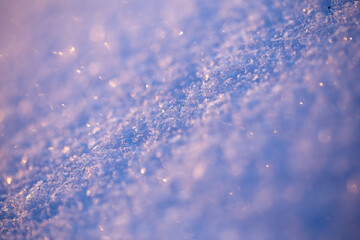 A close-up of a layer of snow against the light. Very shallow depth of field, blurry back and  foreground