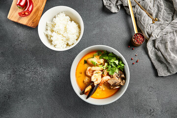 Tom yum soup with spicy seafood. Grey bowl on dark slate table. Thai, asian, authentic food concept