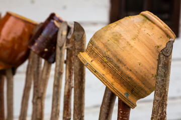 Clay pots hanging on an old fence. Taken in cloudy day, natural soft light