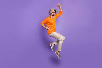 Full size profile side photo of aged man rejoice win victory jump up happy positive smile isolated over purple color background