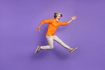 Fototapeta na wymiar Full length profile side photo of aged man jump up wear casual outfit isolated over purple color background