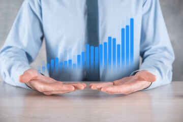 Businessman man holding a graph with positive profits growth. plan graph growth and increase of chart positive indicators in his business.more profitable and growing