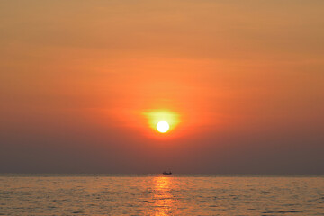Sunrise over the sea with fishing boat in the morning. Thailand.