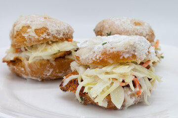Three Delicious Chicken Beignet Sliders with Coleslaw on a White Plate