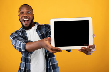 Excited Black Guy Showing Tablet Screen Posing Over Yellow Background