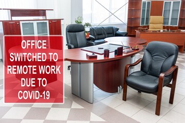 ''Office switched to remote work due to COVID-19'' information sign against an office interior
