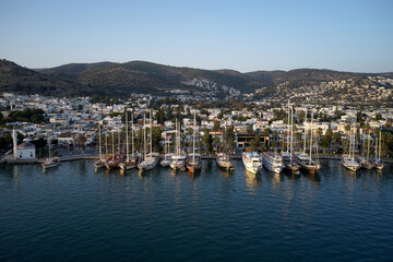 Fototapeta na wymiar Bodrum city and harbor view. Drone view of sea, ships and city with beautiful blue sky in the background. Resort town at Mediterranean sea.