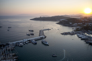 Sunset scenery in Bodrum with boats at harbour. Sunset view of Bodrum Castle and marina bay on Turkish riviera.