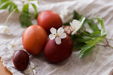 Happy Easter! Modern red easter eggs with spring flowers on rustic linen cloth on wooden table