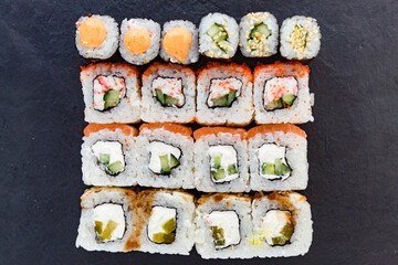 The rolls are lined with stone dishes. A pattern of rolls. Japanese cuisine.