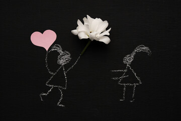 Chalk drawing woman is holding red heart and flower and running to a girl. Blackboard or chalkboard background. Valentines day, love, relationship, attraction concept. Flat lay